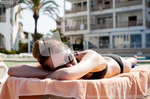 Image of sexy woman in bikini relax on sunlounger sunbathing