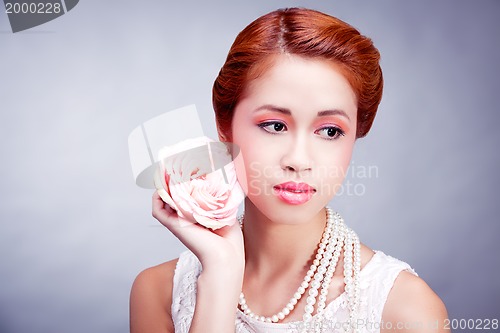 Image of pretty asian woman with flower and pearls