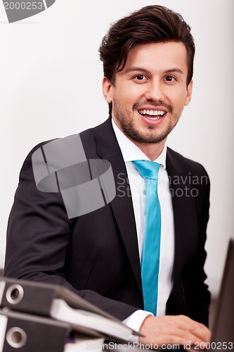 Image of young businessman smiling at office