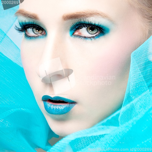 Image of beautiful woman with extreme colorfull make up in turquoise