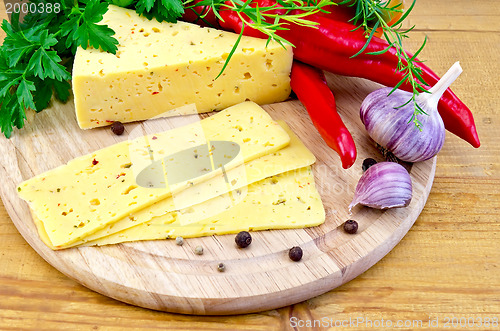 Image of Cheese with spices and herbs on a round board