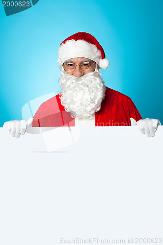 Image of Aged Santa standing behind a blank ad board