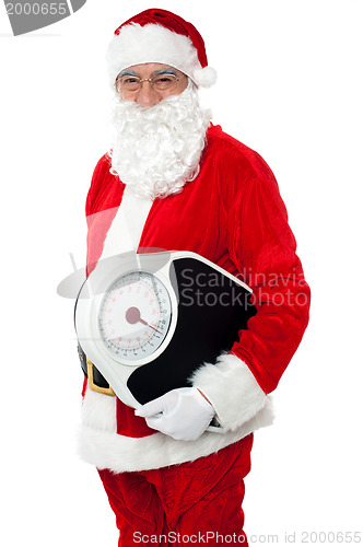 Image of Aged male Santa holding weighing scale