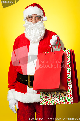 Image of Joyous Santa posing with colorful shopping bags