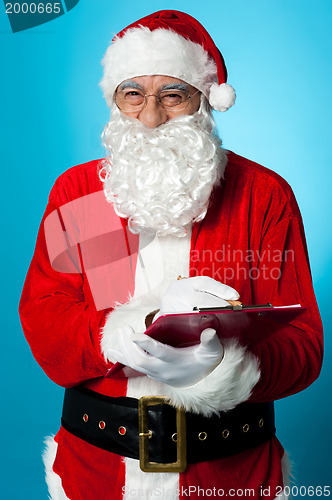 Image of Santa Claus making his list of the good children