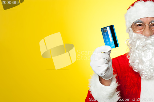 Image of Cropped image of aged Santa holding credit card