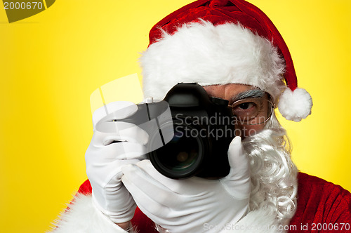Image of Aged Santa adjusting camera lens before click