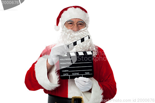 Image of Cheerful aged Santa posing with a clapperboard
