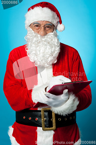 Image of Father Nicholas preparing a list of gift recipients