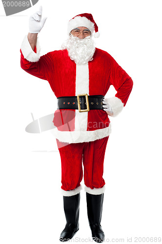 Image of Bespectacled Santa pointing upwards
