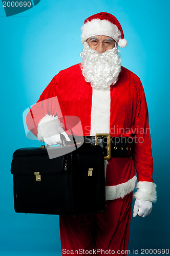 Image of Santa is all set to visit his new office, holding briefcase