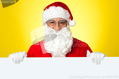 Image of Male Santa standing behind big blank banner ad board