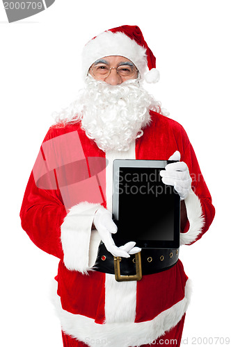Image of Old man in santa costume posing with a tablet pc