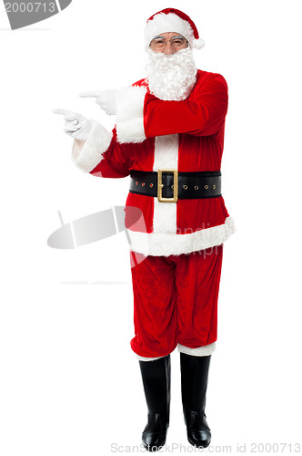 Image of Man in Santa costume indicating at copy space area