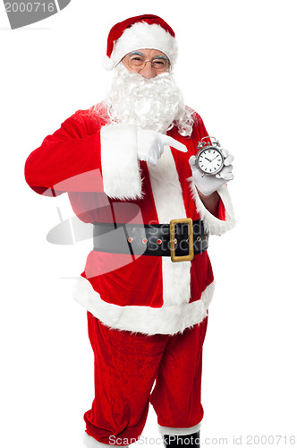 Image of Santa pointing at an antique time piece