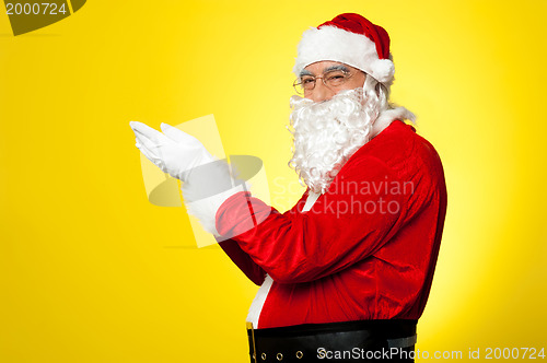 Image of Side profile of Santa facing camera with open palms