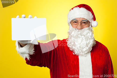 Image of Saint Nick flashing a blank placard to the camera