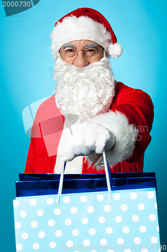 Image of Santa holding shopping bags in his outstretched arms