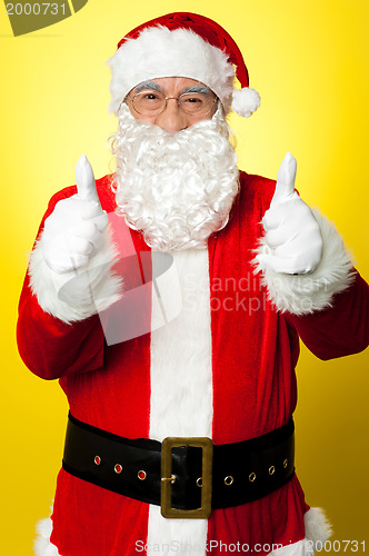 Image of Cheerful male in Santa costume showing double thumbs up