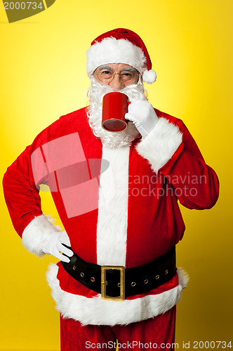 Image of Portrait of a aged Santa sipping coffee