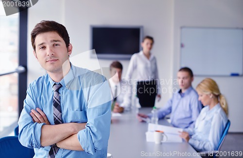 Image of business man  on a meeting in offce with colleagues in backgroun