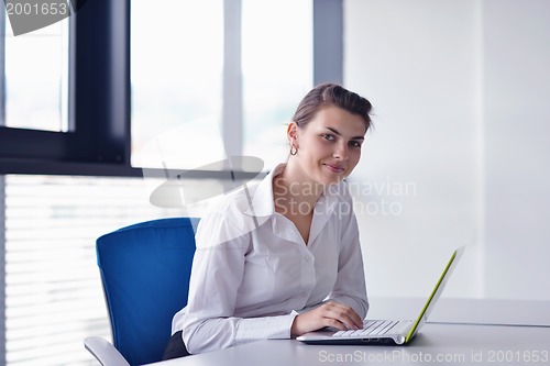 Image of Young pretty business woman with notebook in the office