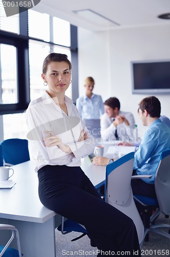 Image of business woman with her staff in background at office