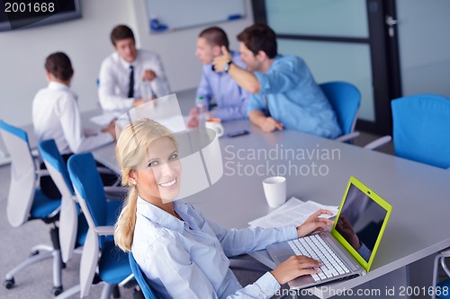 Image of business woman with her staff in background at office