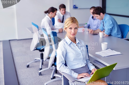 Image of business woman with her staff in background at office