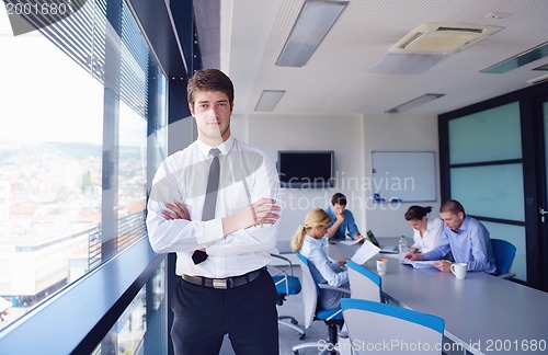 Image of business man  on a meeting in offce with colleagues in backgroun