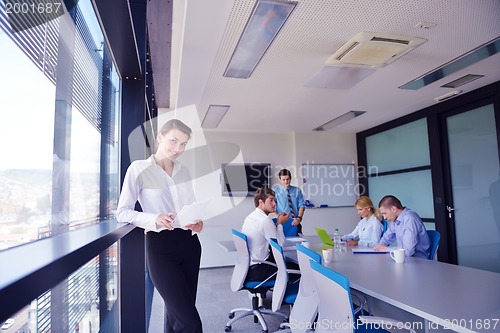 Image of business woman with her staff in background at office