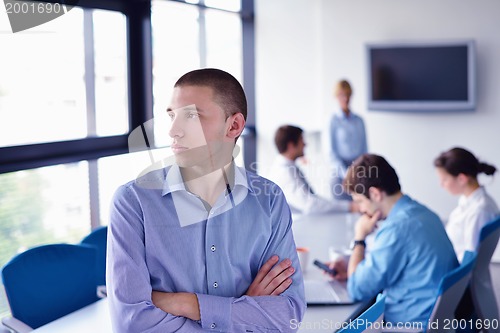 Image of business man  on a meeting in offce with colleagues in backgroun