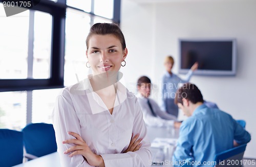 Image of business woman with her staff in background at office