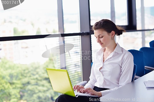 Image of Young pretty business woman with notebook in the office