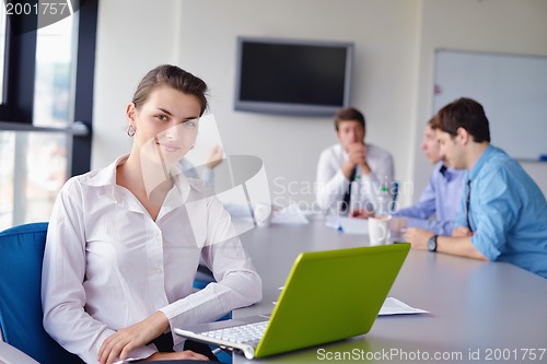 Image of business woman with her staff in background at office