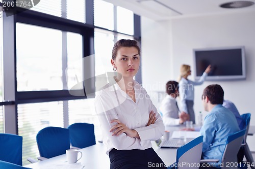 Image of business woman with her staff in background at office