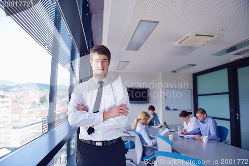 Image of business man  on a meeting in offce with colleagues in backgroun