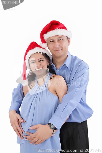 Image of A beautiful young hispanic couple wearing Christmas Santa Hats