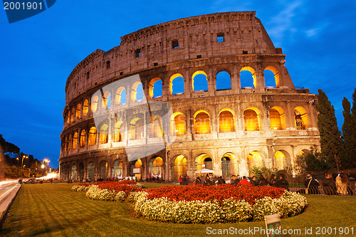 Image of Beautiful view of Colosseum at sunset with flowerbed in foregrou