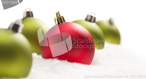 Image of Red and Green Christmas Ornaments on Snow Flakes on White