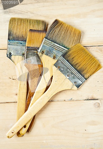 Image of Old paint brushes on wooden background