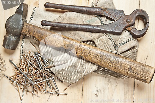 Image of Vintage hammer with nails on wood background