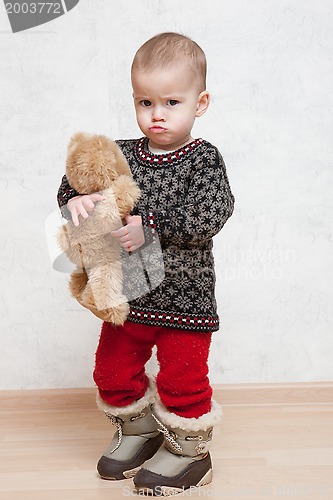 Image of Baby in winter clothes with toy