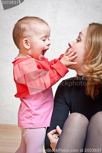 Image of Mother playing with baby daughter