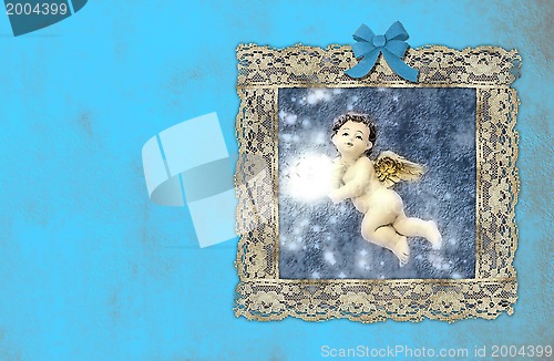 Image of christmas vintage cards, angel in an old painting on blue wall