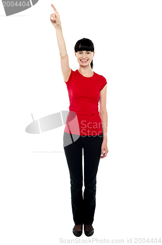 Image of Beautiful female model directing finger upwards