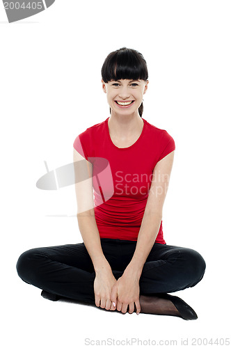 Image of Relaxed smiling trendy woman sitting in studio floor