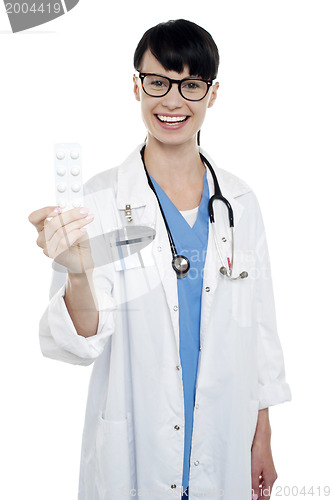 Image of Bespectacled duty doctor showing medicine strip