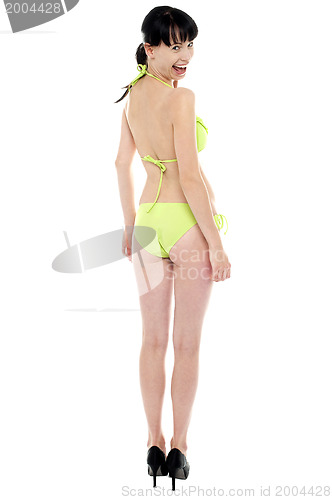 Image of Young, fit and sexy woman in fluorescent swimsuit