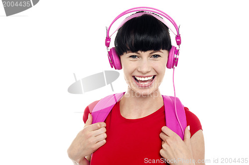 Image of Young girl listening to music, using headphones